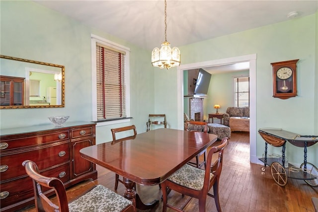 dining space featuring an inviting chandelier and dark wood-style flooring