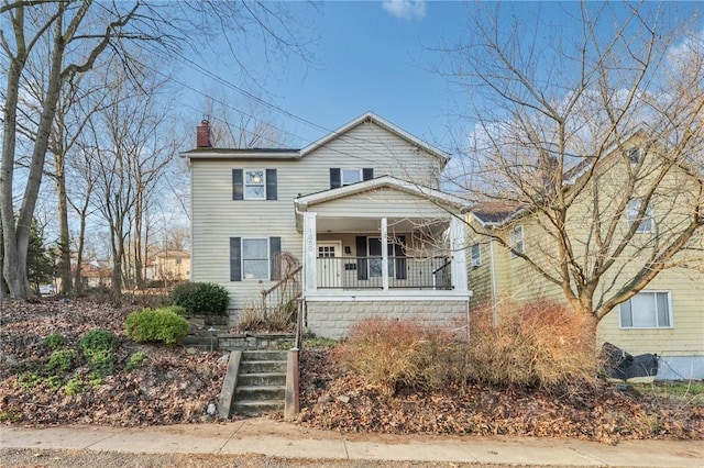 view of front of property with stairway, covered porch, and a chimney