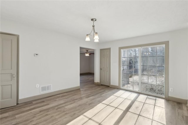 unfurnished dining area featuring ceiling fan, wood finished floors, visible vents, and baseboards