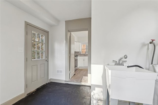 clothes washing area with laundry area, baseboards, visible vents, and a sink