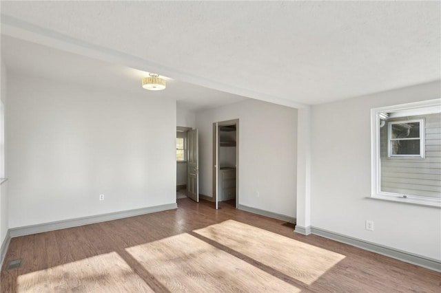 unfurnished room featuring baseboards and wood finished floors