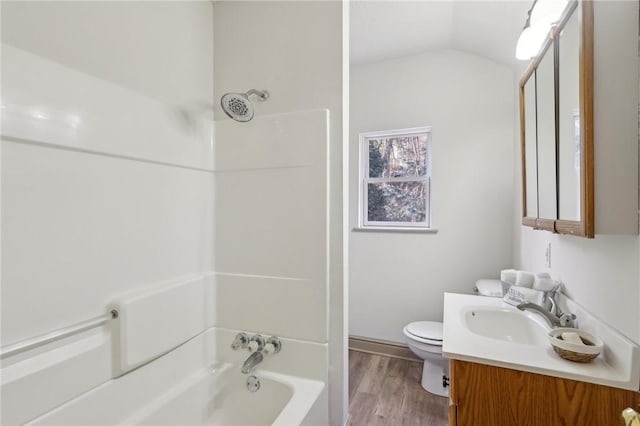 full bathroom featuring toilet, wood finished floors,  shower combination, lofted ceiling, and vanity