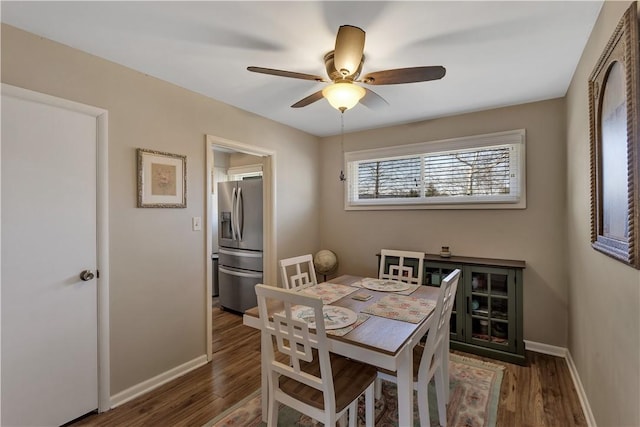 dining room with baseboards, wood finished floors, and a ceiling fan