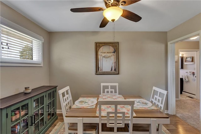 dining room with light wood-style floors, baseboards, baseboard heating, and ceiling fan