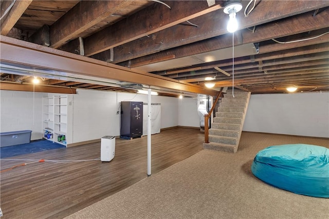 basement with stairway, refrigerator, and wood finished floors