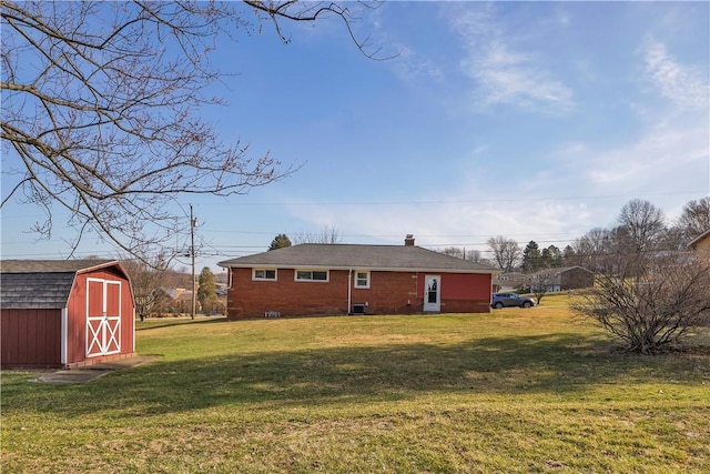 view of property exterior with brick siding, a chimney, a storage shed, a yard, and an outdoor structure