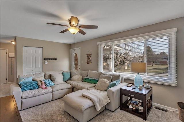 living room with visible vents, baseboards, carpet, and ceiling fan