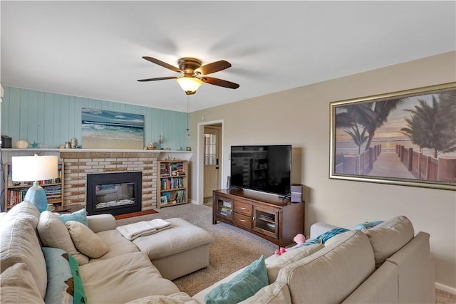 carpeted living area featuring a brick fireplace and ceiling fan