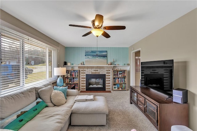 living room featuring carpet, ceiling fan, and a fireplace