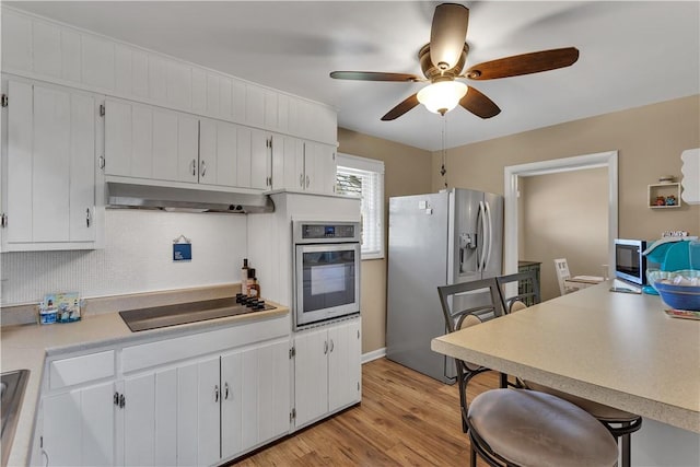 kitchen featuring ceiling fan, stainless steel appliances, light countertops, light wood-style floors, and under cabinet range hood