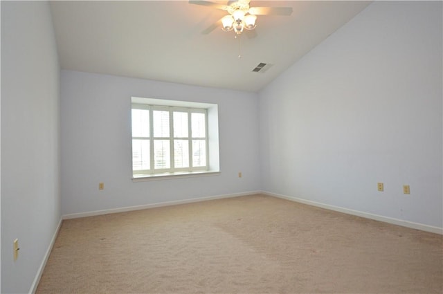 empty room with visible vents, baseboards, ceiling fan, light colored carpet, and vaulted ceiling