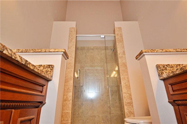 bathroom with a shower stall and toilet