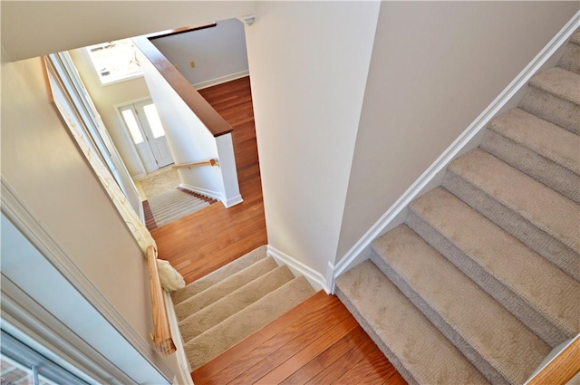 stairway featuring baseboards and wood finished floors