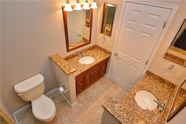 bathroom with toilet, two vanities, baseboards, and a sink