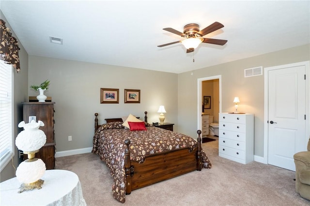 carpeted bedroom featuring visible vents, ensuite bath, baseboards, and a ceiling fan