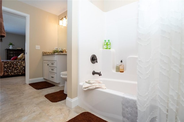 ensuite bathroom featuring vanity, baseboards, shower / bath combo with shower curtain, and ensuite bathroom