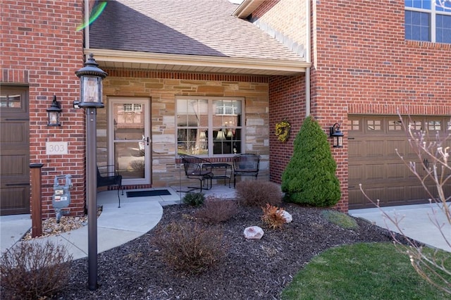 property entrance with a porch, stone siding, brick siding, and roof with shingles