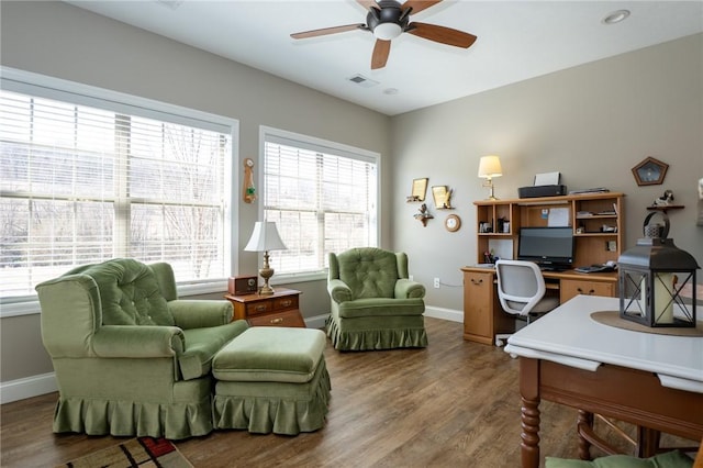 office area with visible vents, baseboards, wood finished floors, and a ceiling fan