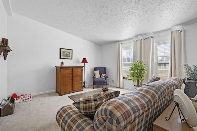 living area with baseboards, light colored carpet, and a textured ceiling