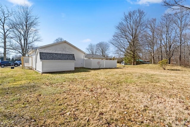 view of yard featuring an outbuilding, a storage shed, and fence