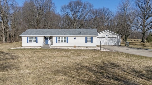 ranch-style home with entry steps, driveway, a front yard, and an outdoor structure