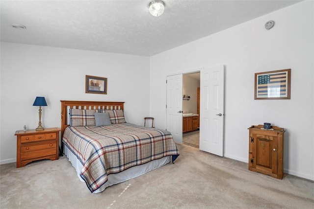 carpeted bedroom featuring connected bathroom, baseboards, and a textured ceiling