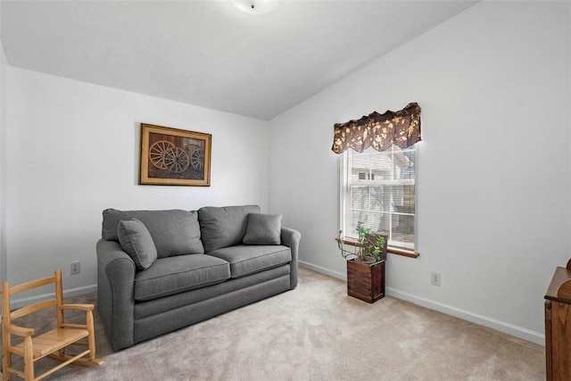 carpeted living room featuring lofted ceiling and baseboards