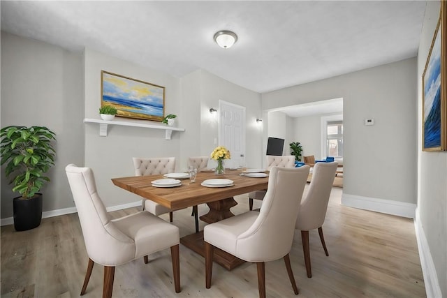 dining room with baseboards and light wood-style floors