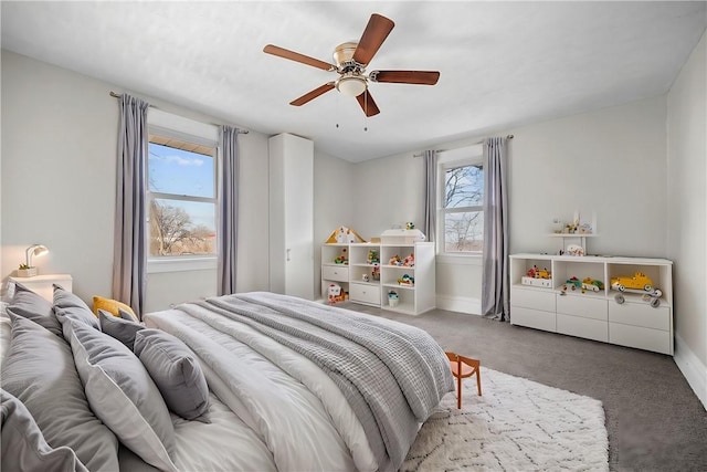 carpeted bedroom with a ceiling fan and baseboards