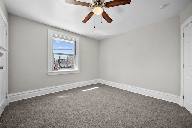 carpeted empty room with baseboards and a ceiling fan