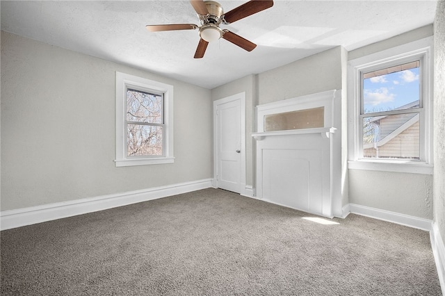 unfurnished bedroom with baseboards, ceiling fan, a textured ceiling, and carpet