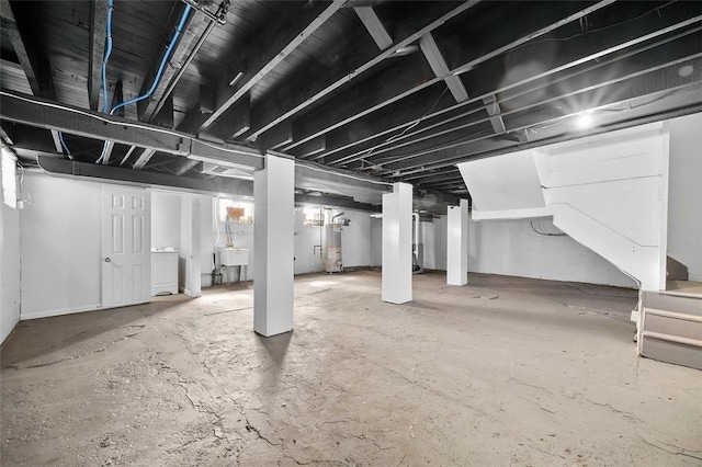 below grade area featuring stairs, water heater, and a sink