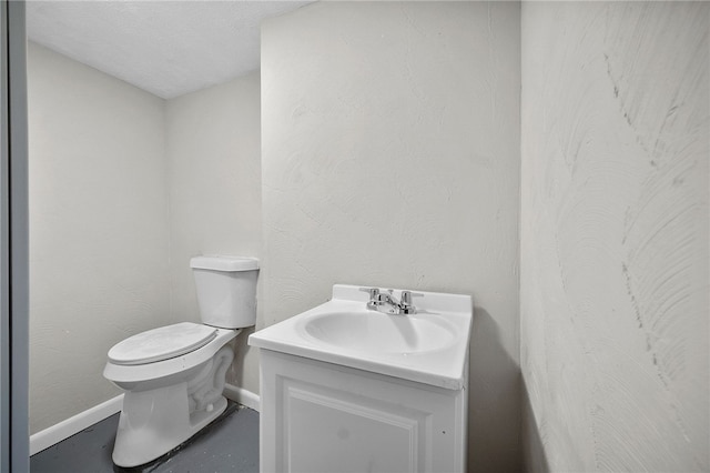 bathroom with baseboards, toilet, and vanity