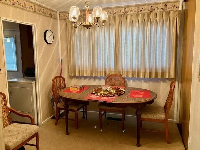 dining area with a notable chandelier, light colored carpet, and washer / clothes dryer