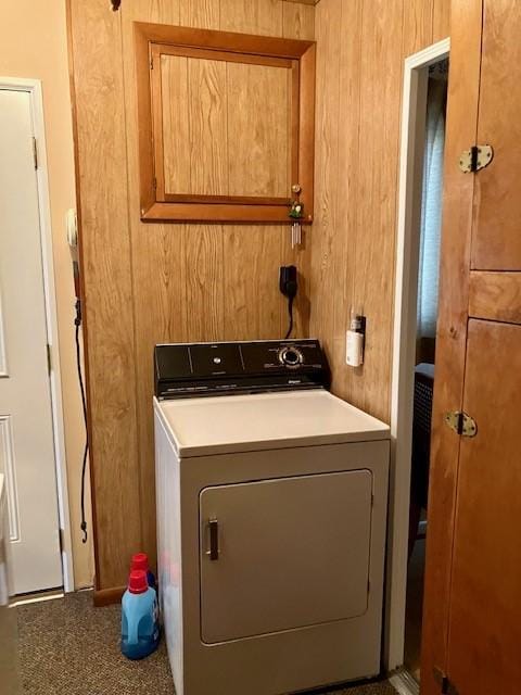 washroom with wooden walls and washer / dryer