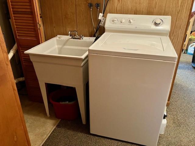 laundry area featuring carpet flooring, washer / clothes dryer, wood walls, and laundry area