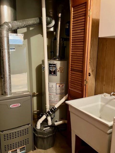 utility room with gas water heater and a sink