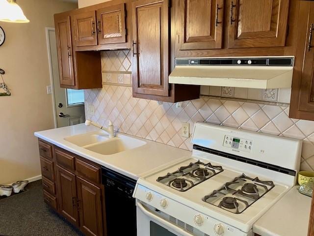 kitchen with white gas stove, under cabinet range hood, light countertops, black dishwasher, and a sink