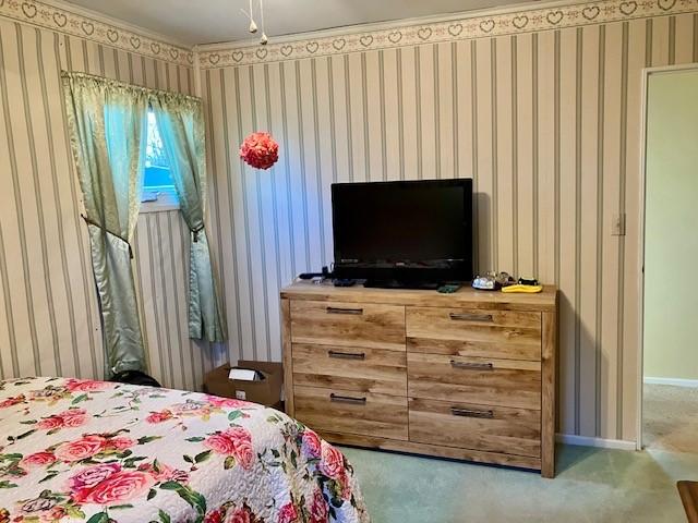 bedroom featuring wallpapered walls, carpet flooring, and baseboards