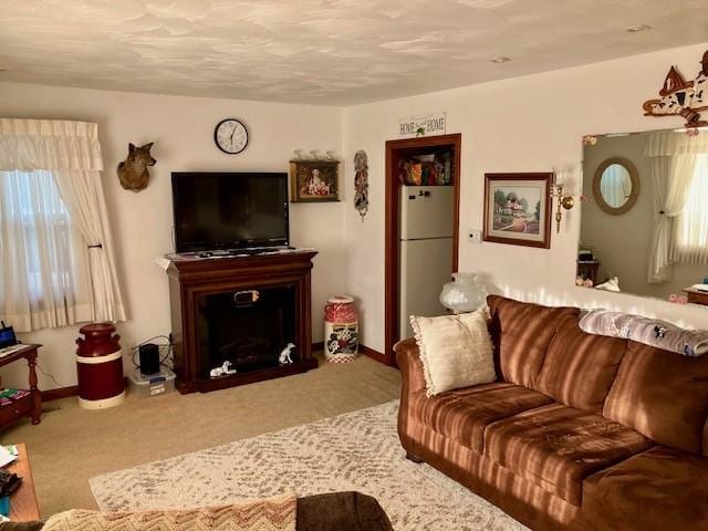 carpeted living area with baseboards and a fireplace