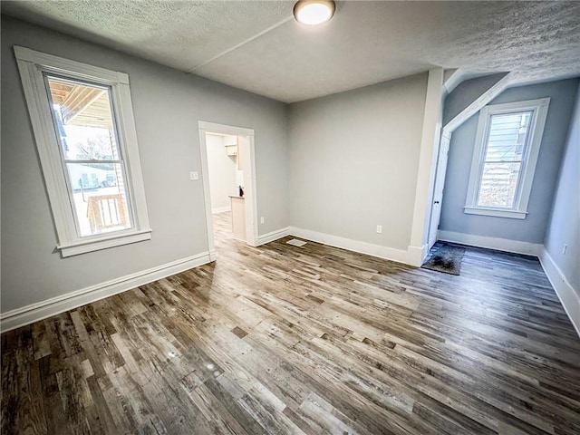 unfurnished bedroom featuring wood finished floors, baseboards, and a textured ceiling