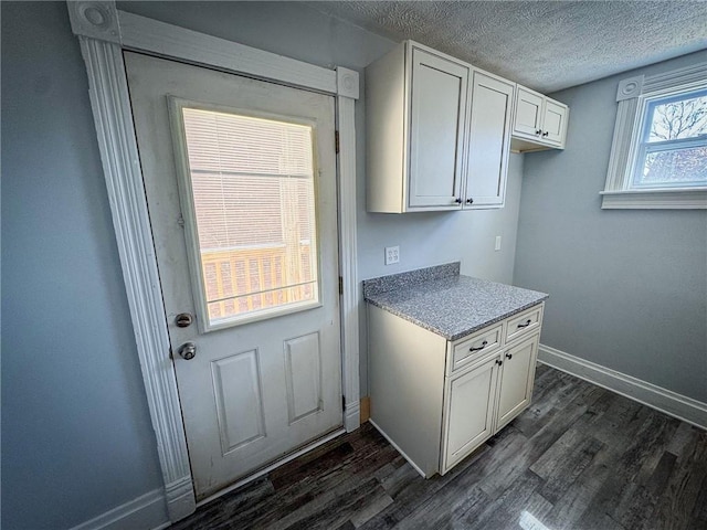 washroom featuring baseboards, a textured ceiling, and dark wood finished floors