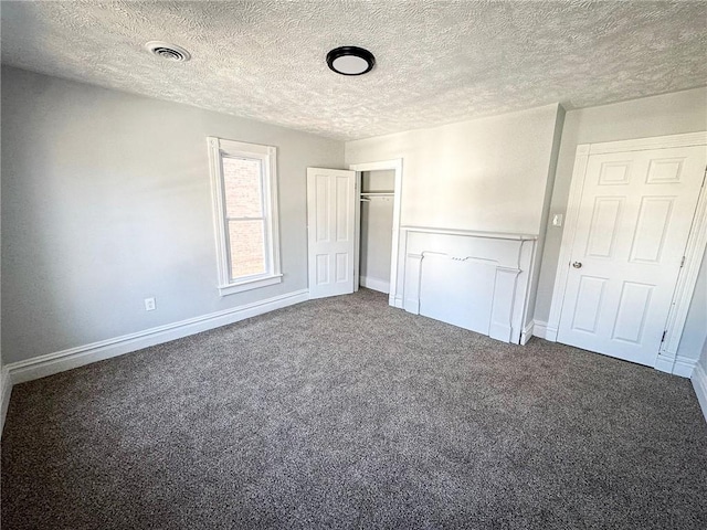 unfurnished bedroom with a closet, visible vents, a textured ceiling, and carpet