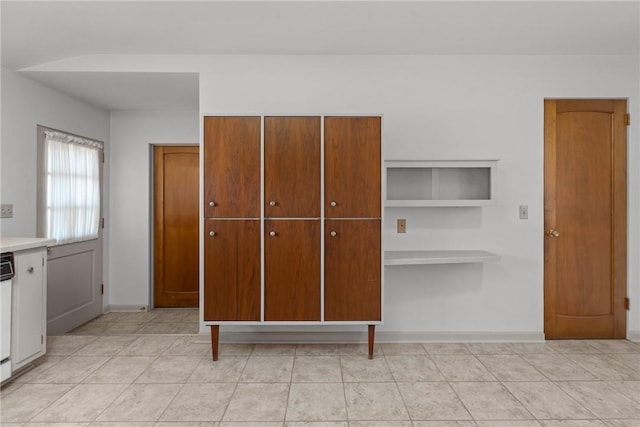 interior space featuring light tile patterned floors, a closet, and baseboards