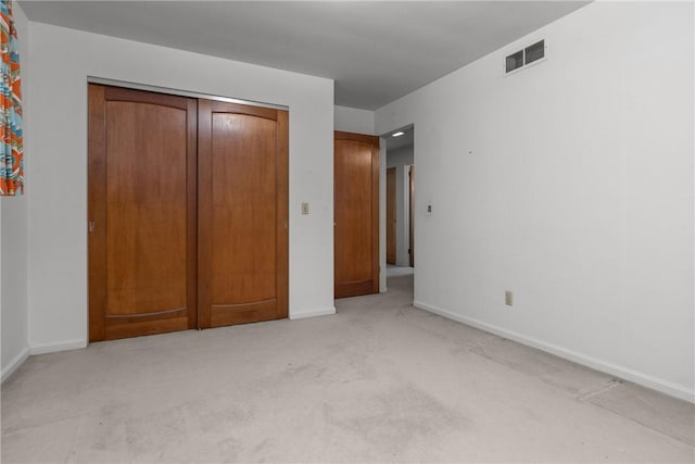 unfurnished bedroom featuring a closet, visible vents, baseboards, and carpet floors