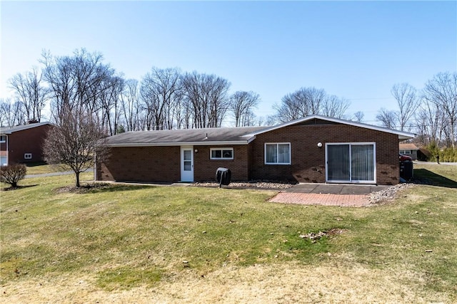 rear view of property with a yard and brick siding