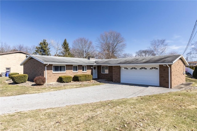 ranch-style house featuring brick siding, an attached garage, a chimney, and driveway