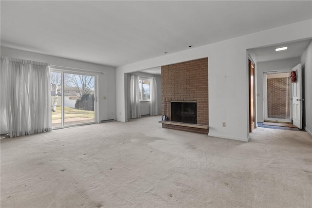 unfurnished living room featuring a fireplace, carpet, and baseboards