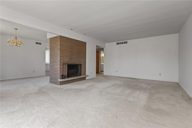 unfurnished living room featuring a brick fireplace, light carpet, visible vents, and a chandelier