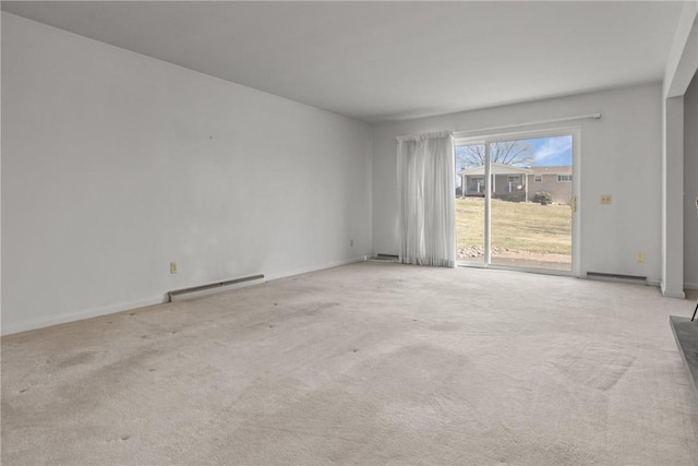 spare room featuring baseboard heating and light carpet